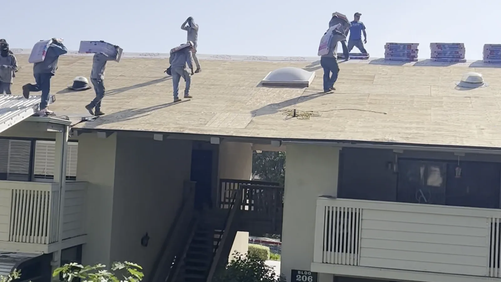 Instalador de Pacific Roofing colocando canaletas nuevas en el alero de un techo