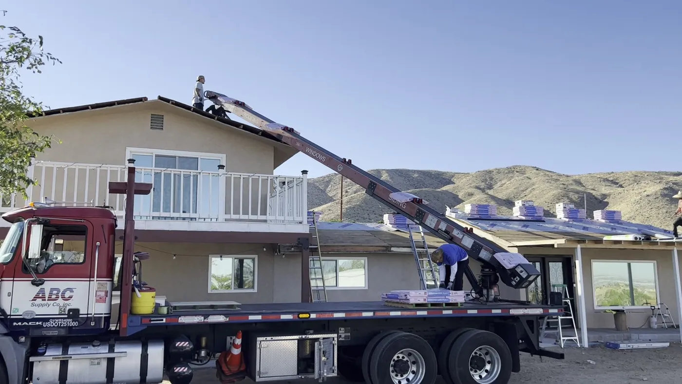 Camion gancho entregando material de techo a una casa de La Habra
