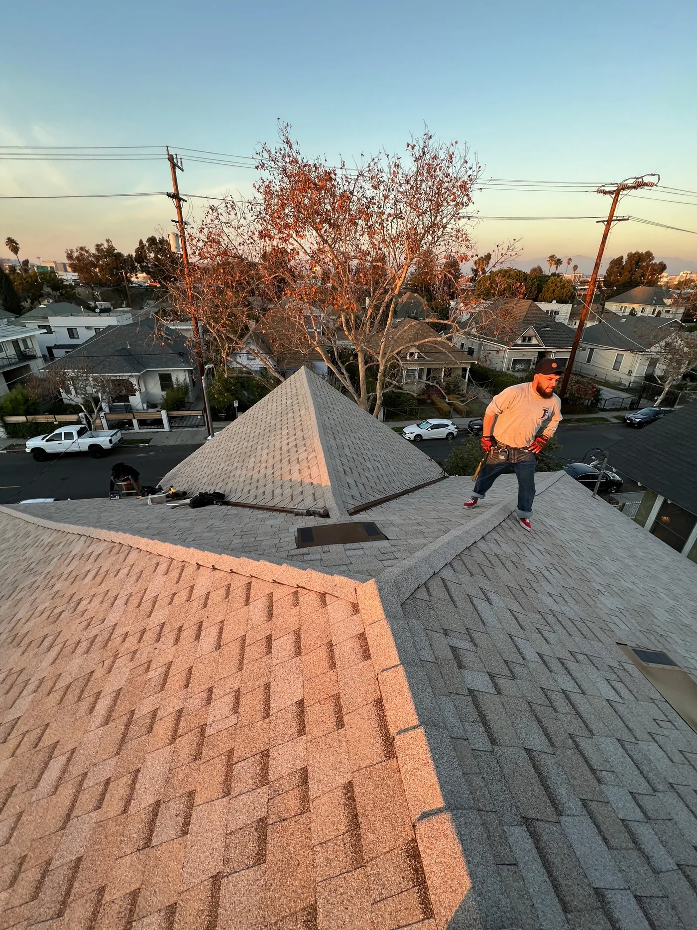 Cuadrilla de Pacific Roofing terminando un techo al atardecer